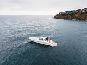 A stylish yacht cruises through calm waters with a group of friends enjoying the day, showcasing the perfect setting for a memorable boating experience.