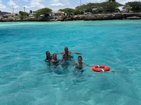 A joyful group enjoys a refreshing swim in the stunning turquoise waters, perfect for family outings and aquatic adventures.