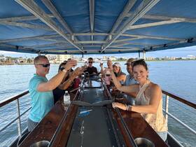 A lively group raises their drinks in a toast aboard a boat, enjoying a fun-filled celebration on the water.