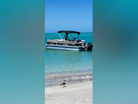 A family enjoys a sunny day on a pontoon boat anchored near a beautiful beach, perfect for swimming and relaxation in the turquoise waters.