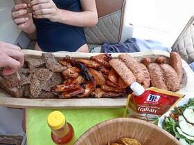 A delicious spread of grilled meats and sides served on a boat, perfect for enjoying a meal while cruising on the water.