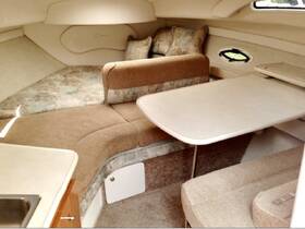 Interior view of a cozy boat cabin featuring comfortable seating and a dining area, perfect for relaxing and enjoying meals while on the water.