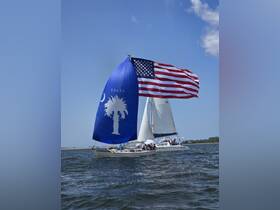 A vibrant sailing scene featuring a boat adorned with an American flag and a palm tree design, showcasing a lively group enjoying their time on the water.