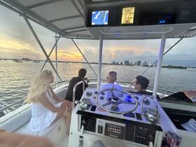 A group enjoys a scenic sunset view from the deck of a boat, capturing the essence of a perfect evening on the water.
