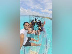 A lively group enjoys a fun day on a boat in stunning turquoise waters, perfect for celebrations and memorable outings.