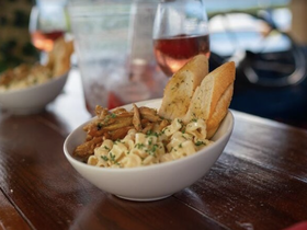 A delicious spread featuring pasta, garlic bread, and a refreshing cocktail, perfect for enjoying onboard during a relaxing day at sea.