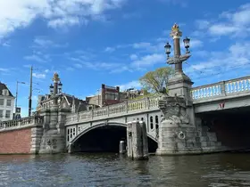 A scenic view of a historic bridge over a waterway, showcasing architectural details against a clear blue sky.