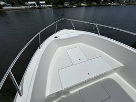 A clear view of the front deck of a boat, showcasing its sleek design and structure against a tranquil water backdrop.