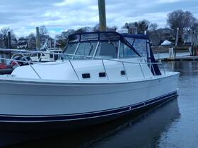 A side view of a well-maintained boat docked at the marina, showcasing its sleek design and structure against a backdrop of a tranquil waterfront.