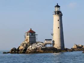 A stunning view of a historic lighthouse perched on rocky shores, showcasing the beauty of coastal scenery and maritime heritage.