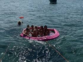 A lively group enjoys a fun day in the water on a floating mat, creating unforgettable memories under the sun.