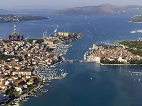A stunning aerial view of a picturesque harbor, showcasing the blend of natural beauty and urban architecture along the coastline.