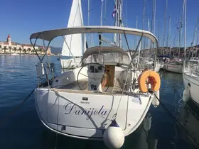 A clear view of the back of the yacht 'Danijela' docked in a marina, showcasing its sleek design and surrounding boats.