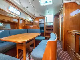 Interior view of a cozy boat cabin featuring comfortable seating and a dining area, perfect for relaxing during your nautical adventures.
