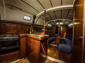 Interior view of a well-appointed boat cabin featuring comfortable seating and a functional galley, perfect for relaxing while at sea.
