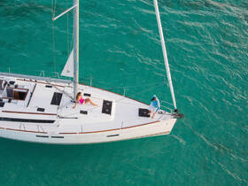 A couple enjoys a relaxing moment on the deck of a yacht, with one sunbathing and the other preparing to sail — a perfect scene for a luxurious day on the water.