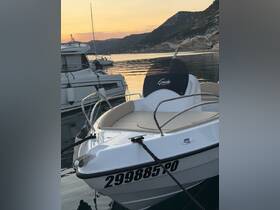 A close-up view of a sleek boat named 'Gaia' docked at sunset, showcasing its elegant design and tranquil surroundings.