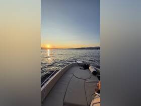 A serene sunset view from the bow of a boat, showcasing the tranquil waters and distant shoreline — perfect for evening cruises.