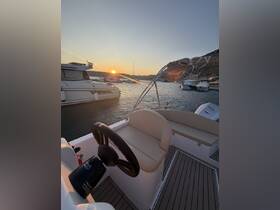 A serene view of the helm and seating area inside a boat, with a stunning sunset visible in the background — perfect for evening cruises.