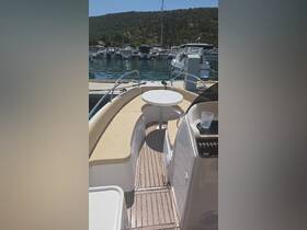 Interior view of a boat featuring comfortable seating and a helm area, perfect for relaxing and navigating on the water.
