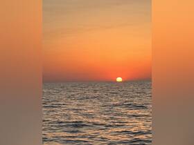 A stunning sunset over the ocean, creating a picturesque backdrop for evening boat adventures.