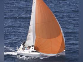 A vibrant sailboat with an orange spinnaker glides through the ocean, showcasing the thrill of sailing adventures on the water.