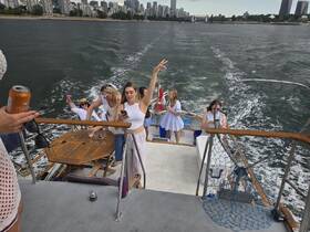 A lively group enjoys a boat party, capturing moments against a stunning city skyline backdrop. Perfect for celebrations and gatherings on the water.