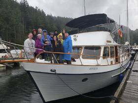 A cheerful group of friends and family gather on the deck of a boat, showcasing a memorable moment together, perfect for family outings or group adventures.