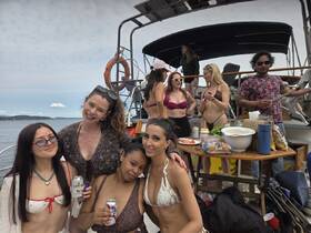 A lively group of friends enjoys a fun day on the water, celebrating with drinks and good company aboard a boat — perfect for summer parties and memorable outings.