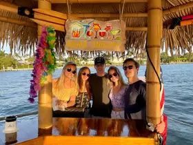 A cheerful group of friends enjoys drinks at a boat bar named 'Group Therapy,' capturing the essence of fun and relaxation on the water.