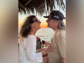 A couple shares a romantic moment at sunset, capturing the essence of love and celebration on the water.