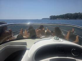 A group of friends relaxes on the deck of a boat, enjoying a sunny day on the ocean — perfect for summer outings and memorable adventures.