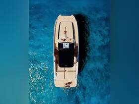 An aerial view captures a couple enjoying the sun on a sleek boat, surrounded by stunning turquoise waters — an ideal scene for romantic getaways or leisurely days on the water.