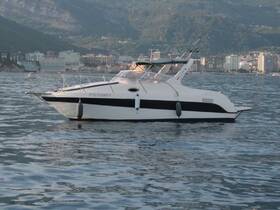 A sleek motorboat is captured in profile, gliding through calm waters with a scenic backdrop of mountains and city buildings, ideal for leisurely cruises.