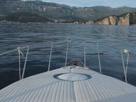 A serene view from the front of a boat, showcasing calm waters and a mountainous backdrop — perfect for a peaceful day on the water.