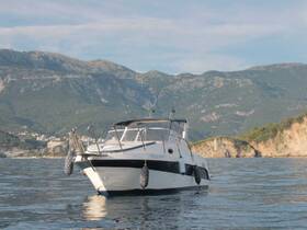 A stunning view of a boat cruising in calm waters, framed by majestic mountains in the background — perfect for showcasing scenic boating adventures.