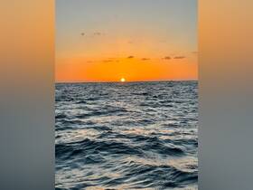 A breathtaking sunset over the ocean, casting vibrant colors across the sky and water — a perfect backdrop for evening boat cruises.