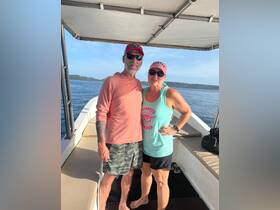 A happy couple poses for a photo on a boat, enjoying a sunny day on the water — perfect for romantic getaways or adventure trips.