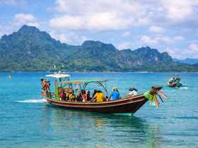 A vibrant group enjoys a boat tour in crystal-clear waters, surrounded by stunning island scenery — perfect for adventure seekers and nature lovers.