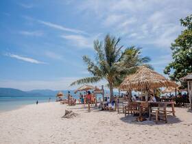 A vibrant beach scene filled with people enjoying the sun and sand, perfect for relaxation and social gatherings.