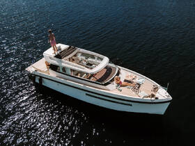 A group enjoys a sunny day on a stylish boat, with one person sunbathing and another standing on the deck, creating a perfect atmosphere for relaxation on the water.