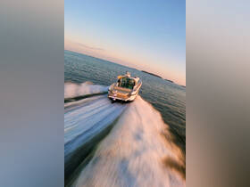 A stunning aerial view of a sleek speedboat cruising through calm waters, showcasing the vessel's design and performance in action.