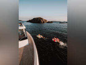 Two friends enjoy a fun day on the water, floating on inflatable rings near a rocky outcrop — a perfect summer adventure.