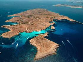 A stunning aerial view of a picturesque island with turquoise waters and rocky coastlines, perfect for exploring and enjoying nature's beauty.