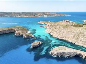 A stunning aerial view of a picturesque coastline featuring turquoise waters and rocky islands, perfect for exploring by boat or enjoying a scenic cruise.
