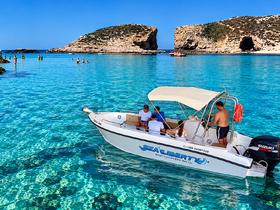A lively group enjoys a day on the water aboard a boat in Malta, surrounded by crystal-clear waters and stunning scenery.