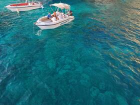 A group enjoys a day on the water aboard a boat, surrounded by stunning turquoise waters — perfect for a fun-filled adventure.