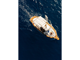 An aerial view of a boat cruising through sparkling blue waters, with guests enjoying the ride — a perfect scene for summer adventures on the water.