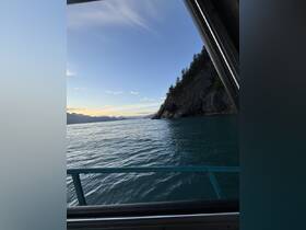 A stunning view of the coastline at sunset, showcasing the tranquil waters and rugged cliffs — perfect for nature lovers and scenic boat tours.