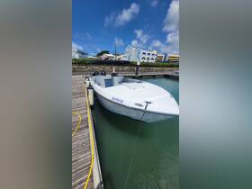 A sleek speedboat docked at the marina, showcasing its modern design against a clear blue sky — perfect for a day out on the water.